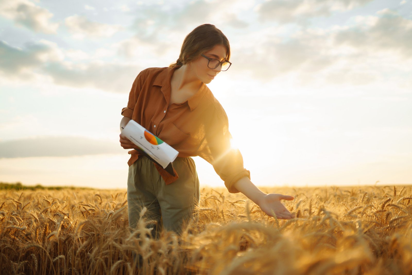 Farmer woman in a wheat field checking crop. Harvesting, gardening or ecology concept. Smart farming