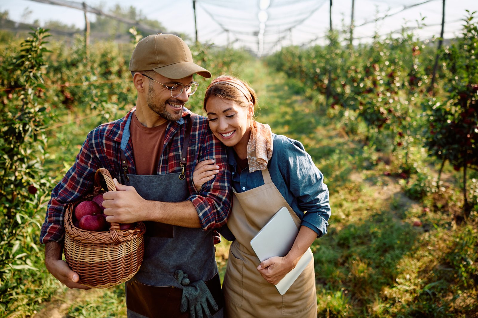 Young happy orchard owners enjoying during autumn harvest.